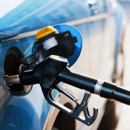 Rinnovabili • Fuel pump nozzle refuelling a vehicle at a petrol station